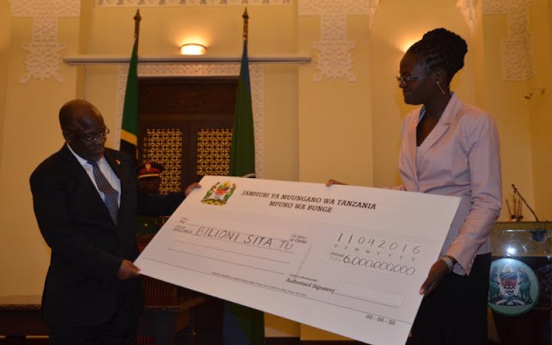 Rais Dkt. John Pombe Magufuli akipokea Hundi Kifani yenye thamani ya Shilingi Bilioni Sita kutoka kwa Naibu Spika Dkt. Tulia Ackson mara baada ya Taasisi ya Bunge kutekeleza kwa vitendo kauli ya kubana matumizi yasio na Tija ili fedha hizo zikanunulie madawati kwa ajili ya wanafunzi.