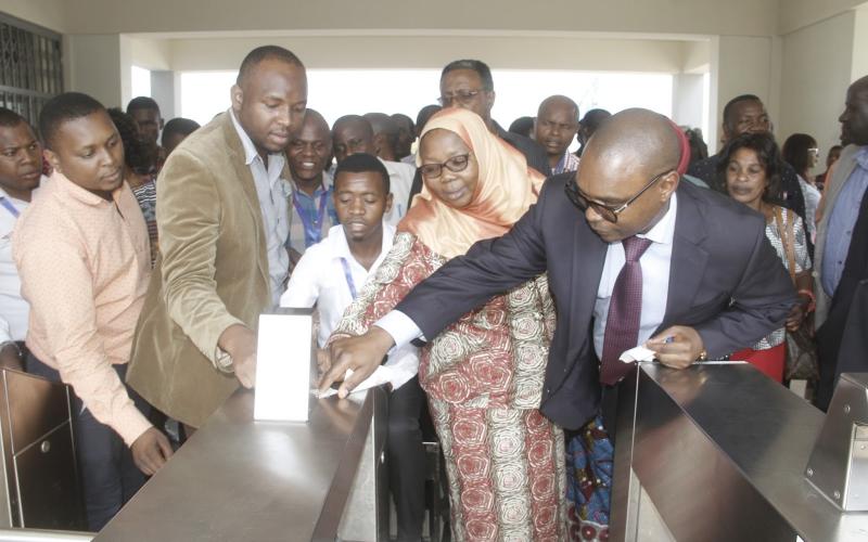 Mkurugenzi wa Kampuni ya Max Com Africa Juma Rajabu akimuonyesha Mwenyekiti wa kamati ya Bunge ya Bajeti, Hawa Ghasia namna ya mfumo wa kutumia kadi unavyo fanya kazi katika vituo vya Mabasi yaendayo haraka katika kituo cha Mabasi ya haraka cha Feri jijini Dar es Salaam.